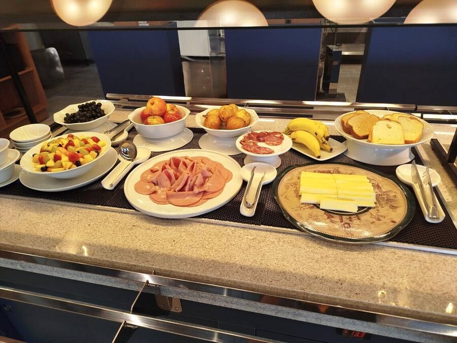 A buffet with various food items including fruits, meats, and cheese.