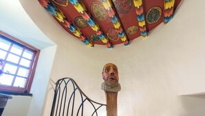 Una escalera con barandilla de madera y un techo decorativo con diseños intrincados.