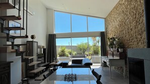 Una cocina moderna con una amplia mesa de comedor, electrodomésticos integrados y una pared de acento de piedra.