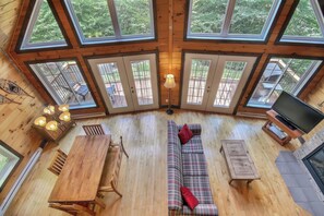 A wooden interior with a sofa, table, and TV.
