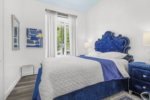A bedroom with a large bed, a nightstand, a lamp, and a window with curtains. - La Citadelle du Château Traversier Levis-Québec Ground floor 8 passengers (Lévis)