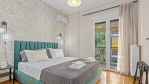 A bedroom with a bed, a nightstand, a lamp, an air conditioning unit, and a view of the outdoors through a sliding glass door. - Your Athens Apartment near Acropolis II (Athina)