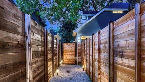 A wooden pathway leading to a wooden gate, surrounded by wooden fences.