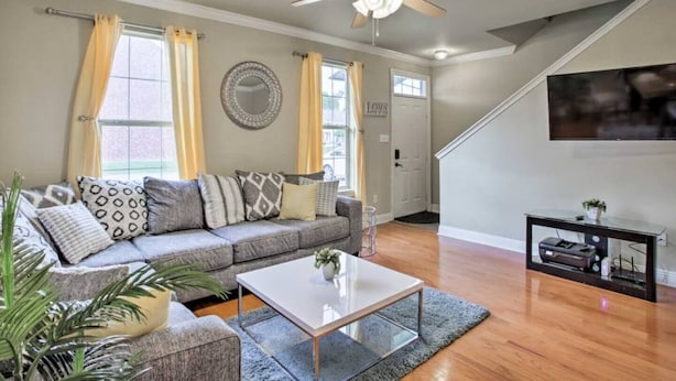 A living room with a sofa, coffee table, and a TV on a stand.