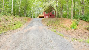 A red cabin with a porch, surrounded by a forest. - Pet-Friendly Lake Monticello Home w/ Perks! (Palmyra)