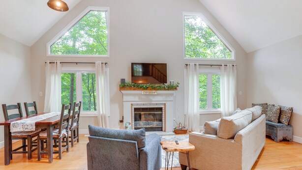A spacious living room with a fireplace, a dining area with chairs, a sofa, and a TV. - Pet-Friendly Lake Monticello Home w/ Perks! (Palmyra)