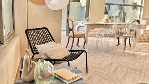 A modern interior with a herringbone wood floor, a marble table, and a seating area with a black metal chair and a wooden chair with a polka dot cushion. - Grande Casa (Stellenbosch)