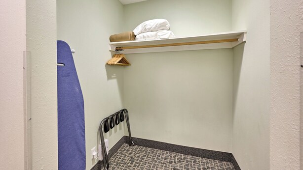Una stanza piccola e stretta con un letto a castello, un appendiabiti per asciugamani e un termosifone.