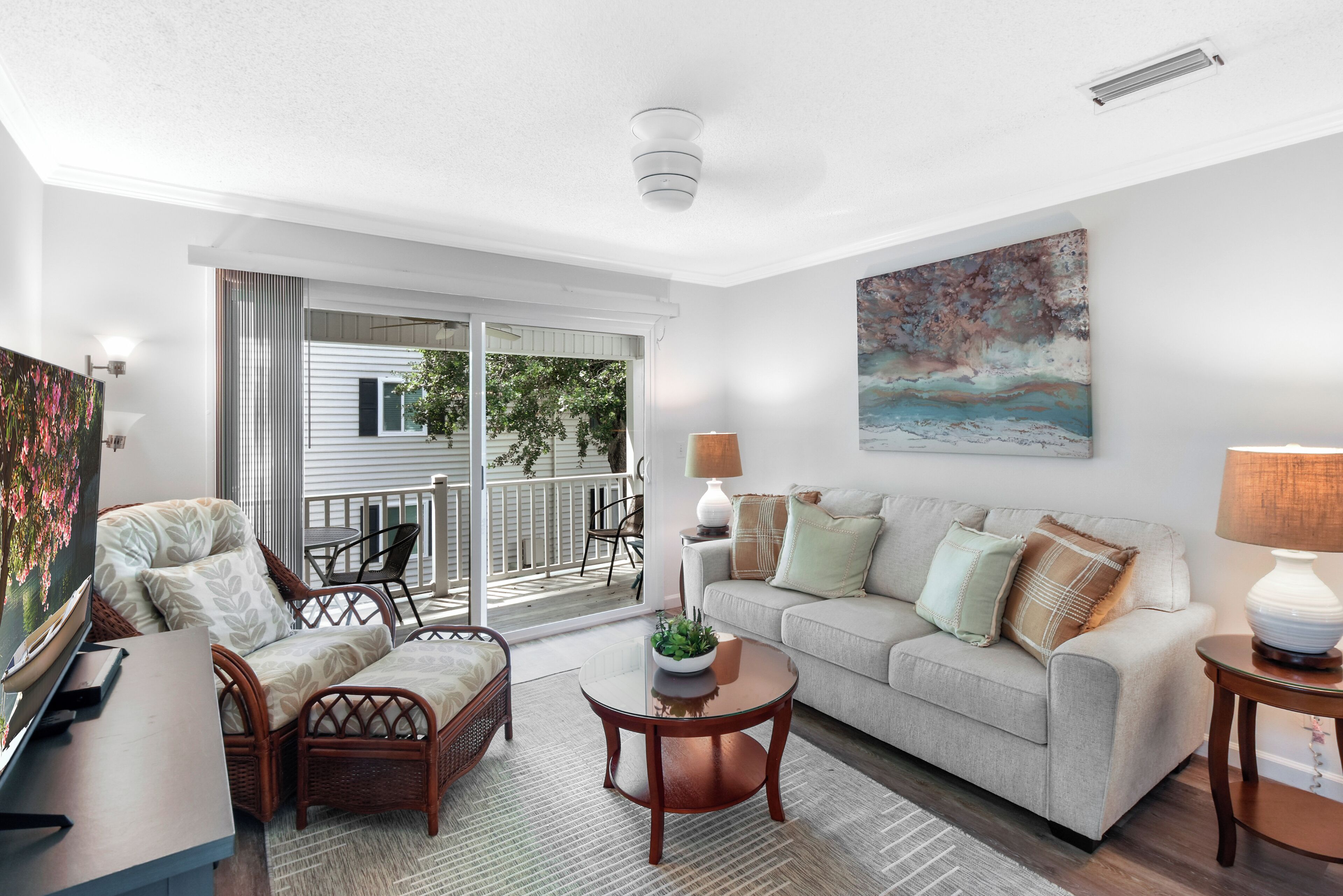 A modern living room with a sofa, chairs, a coffee table, and a painting.