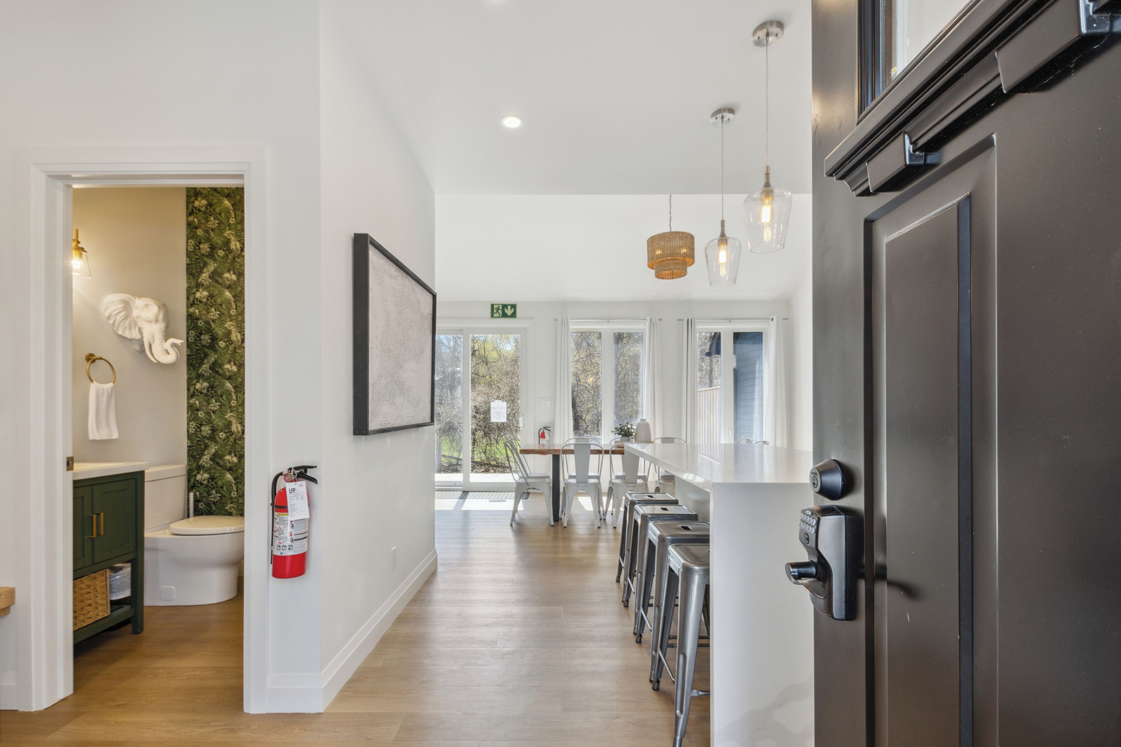A modern kitchen with a central island, stainless steel appliances, and a view of the outdoors.