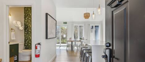 A modern kitchen with a central island, stainless steel appliances, and a view of the outdoors.