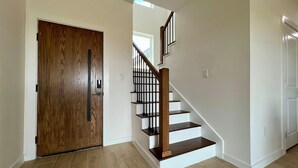 Una escalera de madera con barandilla que lleva a un piso superior.