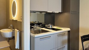 A modern kitchen with a built-in sink, two stovetops, and a large cabinet. - Sulmare Studios - Molocali Sea View (Alba Adriatica)