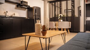 Ett modernt kök med en inbyggd ugn och en matplats med ett träbord och stolar.