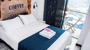 Ett hotellrum med en säng, utsikt över staden och en balkong med en stol.