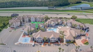 A resort with multiple buildings, a swimming pool, and a parking lot.
