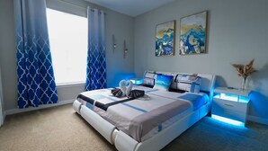 A modern bedroom with a large bed, a bedside table, and a nightstand. - Amazing Condo near Disney World (Kissimmee)