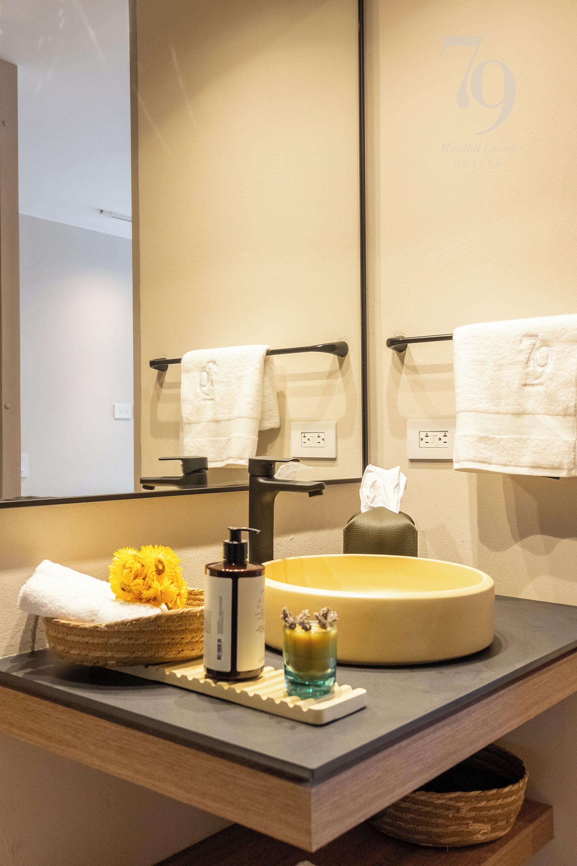 A bathroom with a large mirror, a sink, and two towel racks.