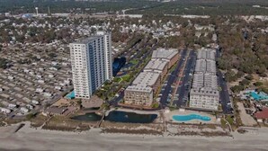 An aerial view of a coastal residential area with high-rise buildings, a marina, and a beach. - Oceanfront Gem (Myrtle Beach)