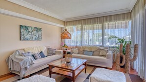 A living room with a sofa, a coffee table, and a large window with curtains. - Villa Kentia Mallorca, stylish country house close to Palma (Palma)