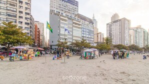 Ein belebtes Stadtgebiet am Strand mit verschiedenen Ständen und Menschen.