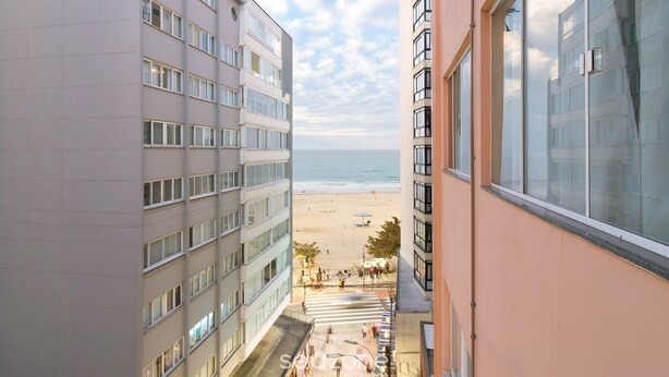 Ein Hochhotel mit Blick auf einen Strand und freiem Meerblick.