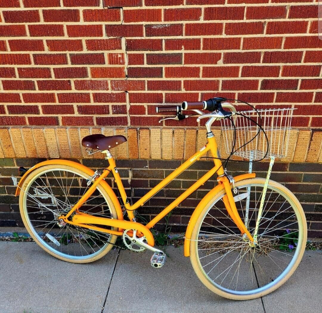 Ein gelbes Fahrrad, das an einer Ziegelwand steht.