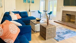 Una sala de estar con un sofá azul, una mesa de centro y una chimenea.