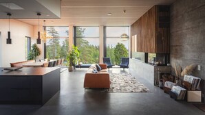 Un salon moderne doté d’une grande fenêtre, d’une cheminée et d’un coin repas.