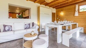 A modern interior with a white sofa, round coffee table, and dining table set for six.