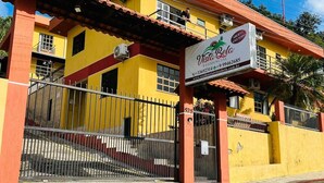 A yellow building with a sign reading "Vista Bela Residencial" and a gated entrance.