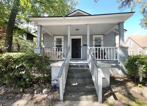A two-story house with a front porch, a staircase, and a security camera. - Grandma's Cottage, Free Off-Street Parking, and Library (Savannah)