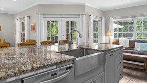 A spacious kitchen with granite countertops, a stainless steel sink, and a built-in oven. - Seacrest 4BR w/ Private Heated Pool + Beach Access & Dolphin Cruise Ticket! (Panama City Beach)
