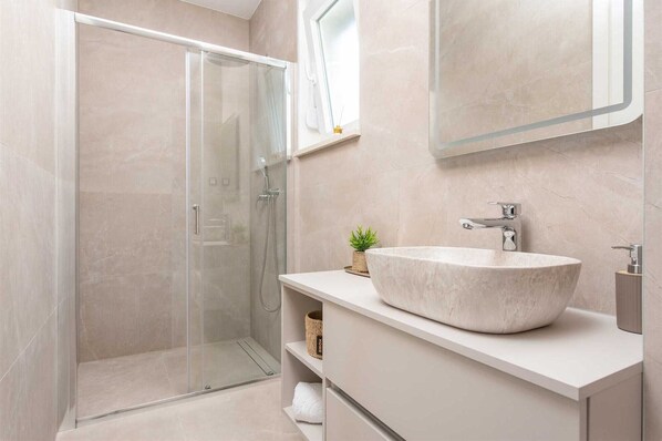 A modern bathroom with a glass shower enclosure, a large marble sink, and a minimalist vanity. - Villa Vista Vinea – Private heated pool villa close to Split and Trogir (Kaštel Novi)