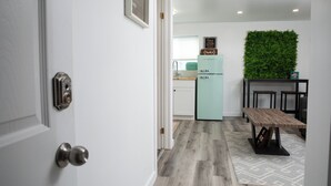 A modern kitchen with a teal refrigerator, a wooden bench, and a green wall. - Bright and Cozy Basement Oasis in the Minnow Lake area (Greater Sudbury)