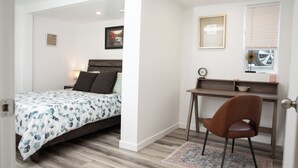 A bedroom with a bed, a desk, a chair, and a window with blinds. - Bright and Cozy Basement Oasis in the Minnow Lake area (Greater Sudbury)