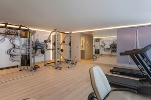 A modern gym with a treadmill, weight machines, and a mirror wall. - Flat pé na areia branco Haus My flats  (Joao Pessoa)