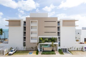 Un edificio moderno con techo plano, ventanas amplias y una entrada central.