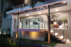 Un edificio moderno con fachada de vidrio, una escalera visible y un letrero que dice 'BRANCO'.