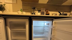 A compact kitchen with a refrigerator and a microwave. - M&C Departamento República 815 (Santiago)