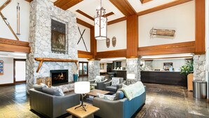A spacious lobby with stone walls, a fireplace, and a reception desk.
