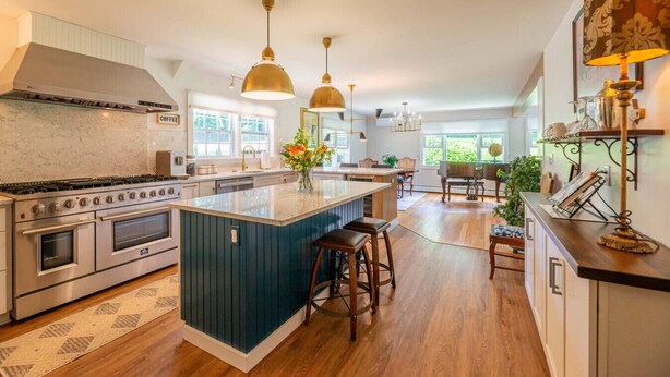 A spacious kitchen with a central island, stainless steel appliances, and pendant lighting. - 1812 House, 2 Stays, 1 home (Manchester)