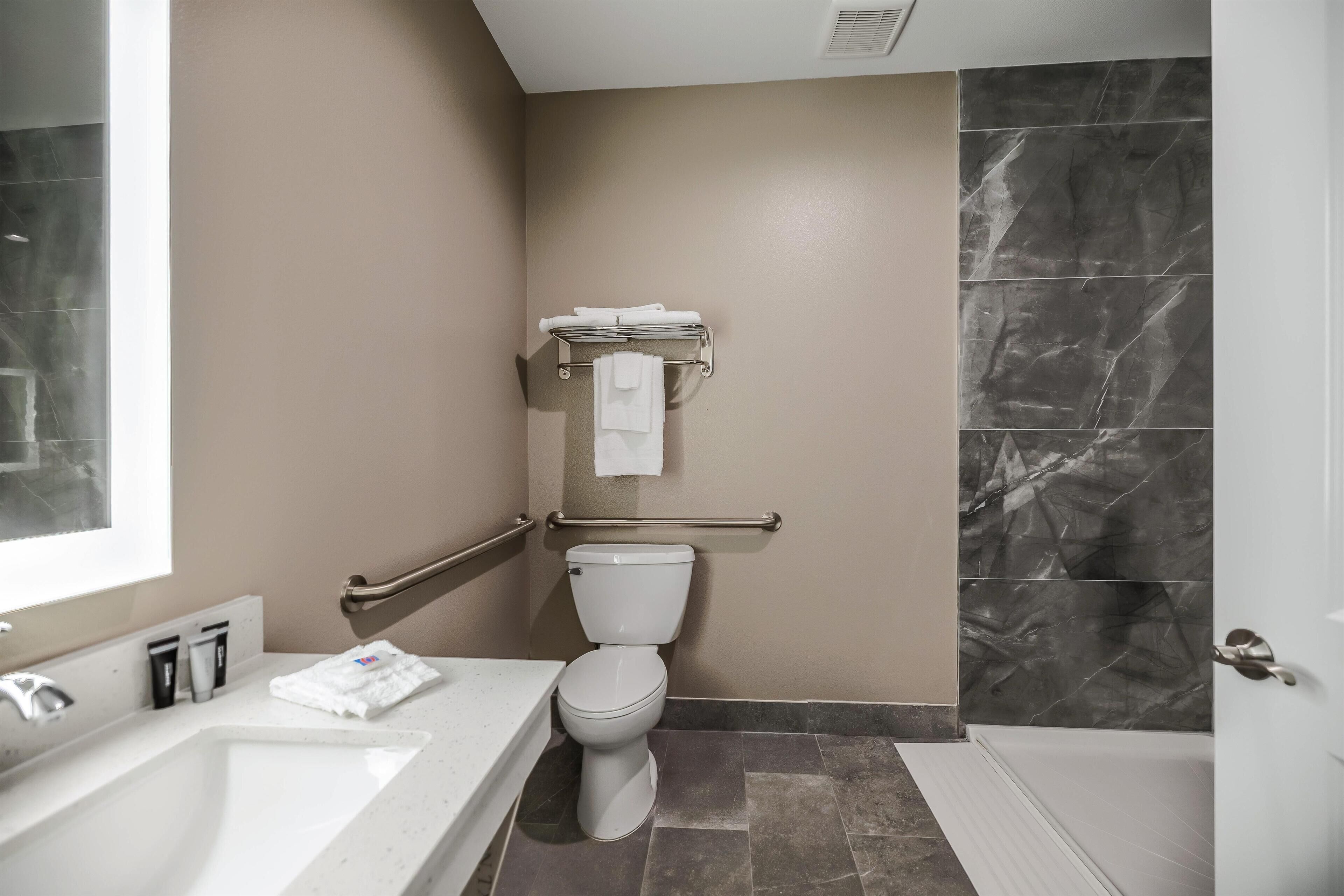 Une salle de bain moderne avec des toilettes blanches, un lavabo et une baignoire.
