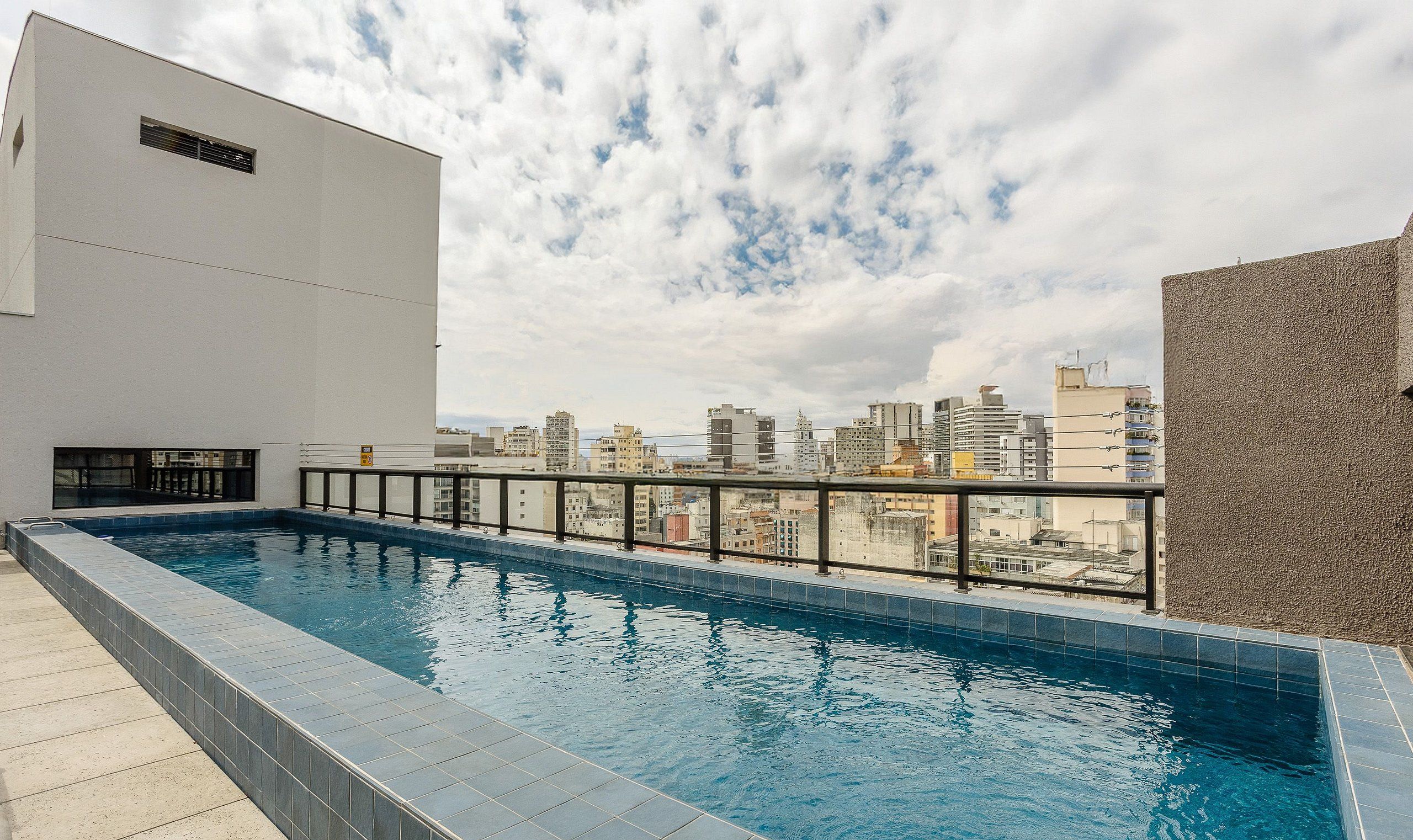 Ein Dachpool mit Blick auf die Stadt, umgeben von Gebäuden.