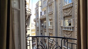 Vista de un edificio con detalles arquitectónicos ornamentales, incluyendo balcones decorativos y elaborada labor de cantería.