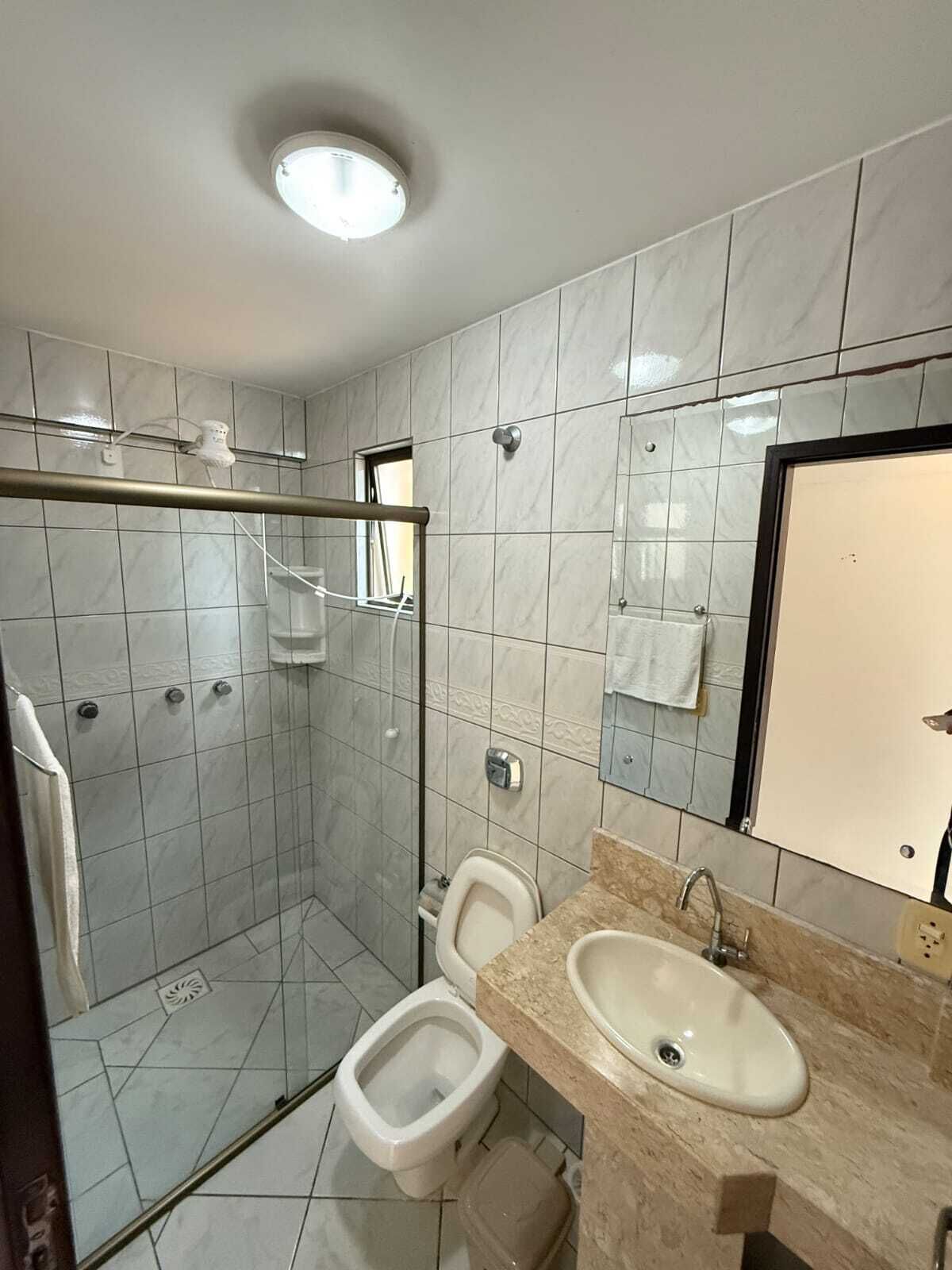 Ein Badezimmer mit Dusche, Toilette und Waschbecken.