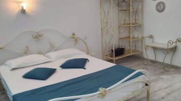 A bedroom with a bed, a bedside table, a wardrobe, and a wall-mounted light.