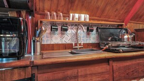 A compact kitchen with wooden cabinetry, a built-in stove, and a backsplash with geometric tiles. - Dashing Dennis - 22 (Launceston)