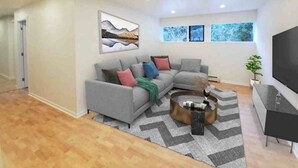 Een moderne woonkamer met een grijze modulaire bank, een salontafel en een flatscreen televisie.