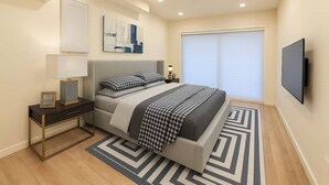 Een moderne slaapkamer met een bed, nachtkastjes, een televisie en een raam met jaloezieën.
